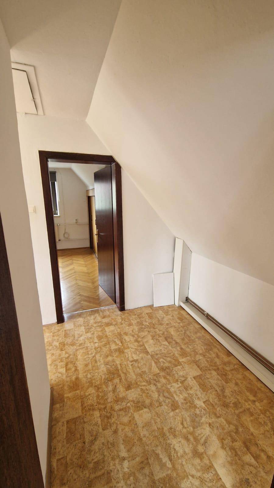 Kleiner Raum mit Dachschräge und gemustertem Bodenbelag, möglicherweise ein Flur.