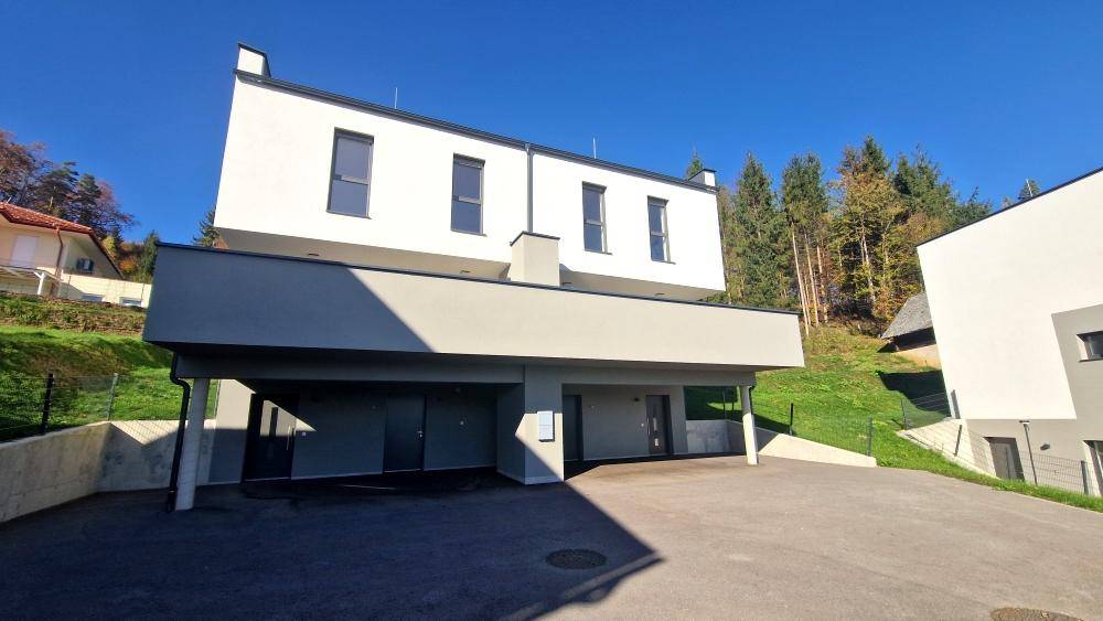 Zeitgenössisches Gebäude mit klarer Linienführung und weißer Fassade unter strahlend blauem Himmel.