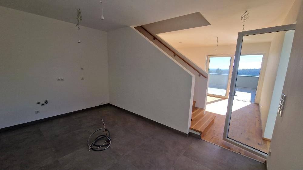 Heller Flurbereich mit Treppe und Zugang zu weiteren Räumen mit Holzboden.