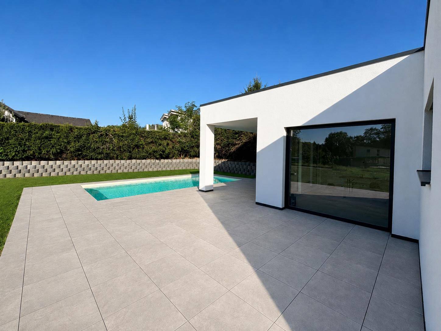 Moderne Architektur des Bungalows mit großen Glasfronten, Terrasse und integriertem Pool.