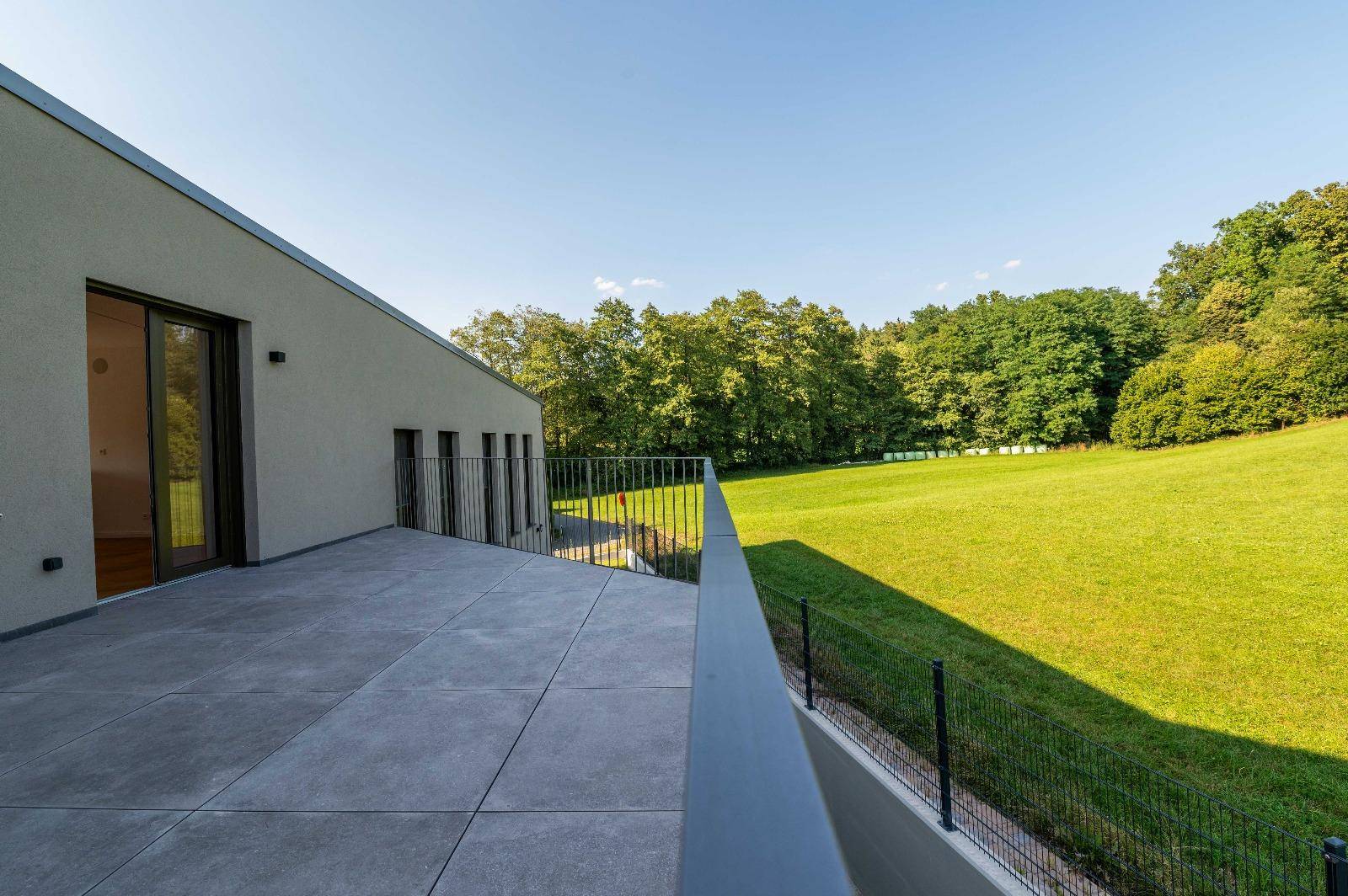 Weitläufige Terrasse mit Blick auf die umliegenden Wälder und Wiesen.