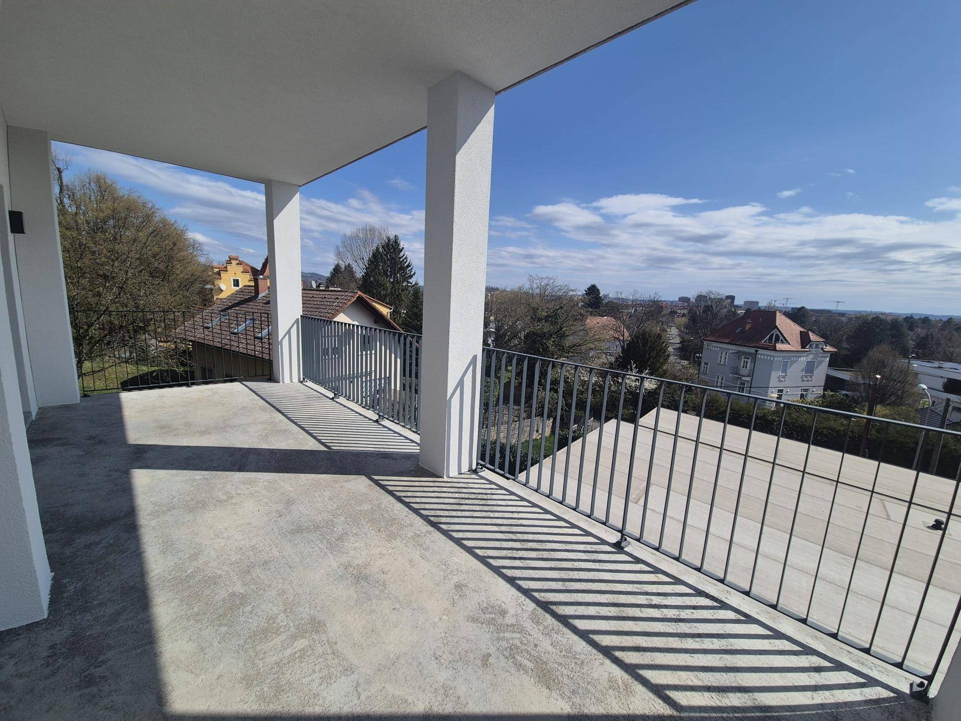 Großzügige Terrasse mit weitem Ausblick über die Dächer der Stadt und die grüne Umgebung.