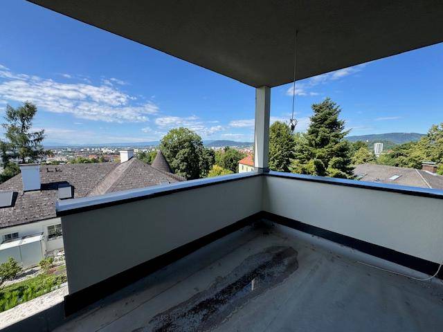 Geräumiger, unfertiger Balkon mit weitem Blick auf die Stadt und die grüne Hügellandschaft.