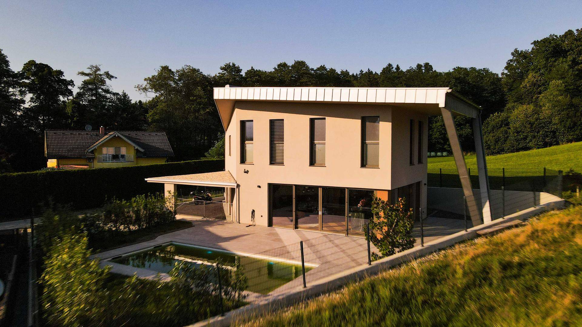 Luftaufnahme der modernen Villa mit Pool und umgebender grüner Landschaft.