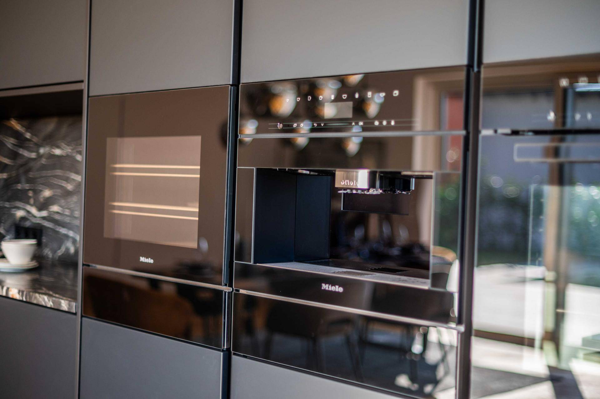 Integrierter Backofen und Kaffeemaschine von Miele in der modernen Küche.