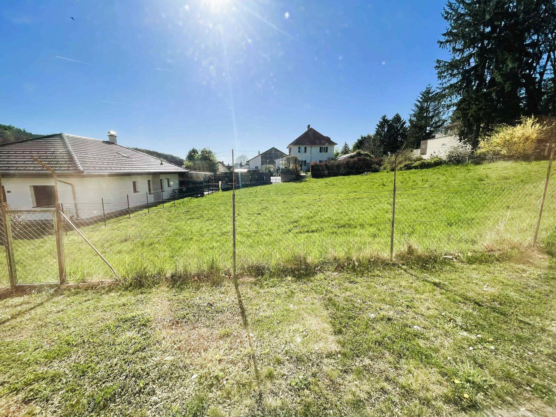 Weitläufiger Gartenbereich mit Rasenfläche und Blick auf die umliegende Natur und Hügel.