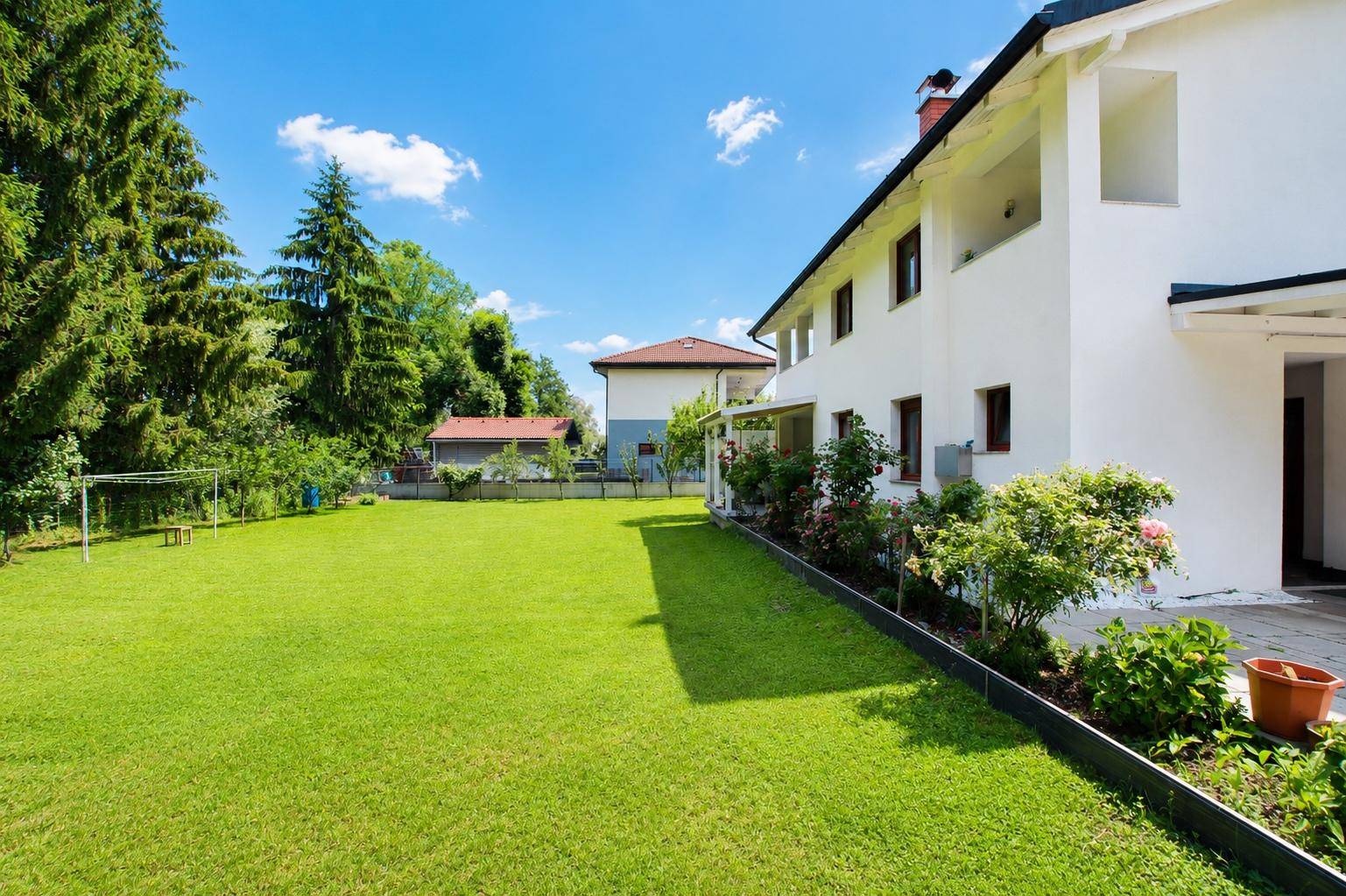 Weitläufiger Garten mit sattgrünem Rasen und Blick auf die moderne Hausfassade.