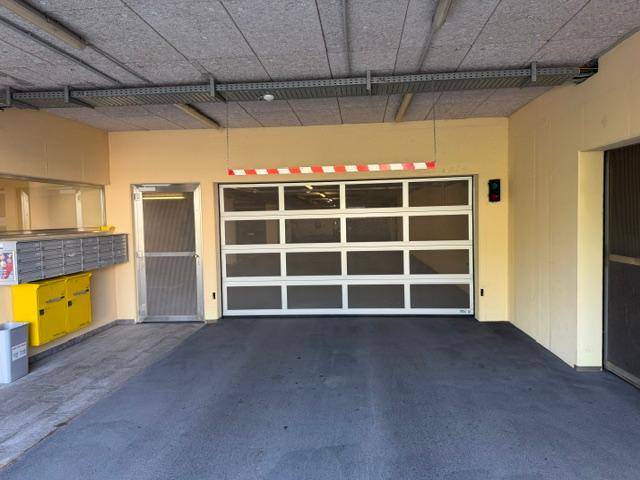 Eingang zur Tiefgarage mit Rolltor, Briefkästen und Zugang zum Gebäude.