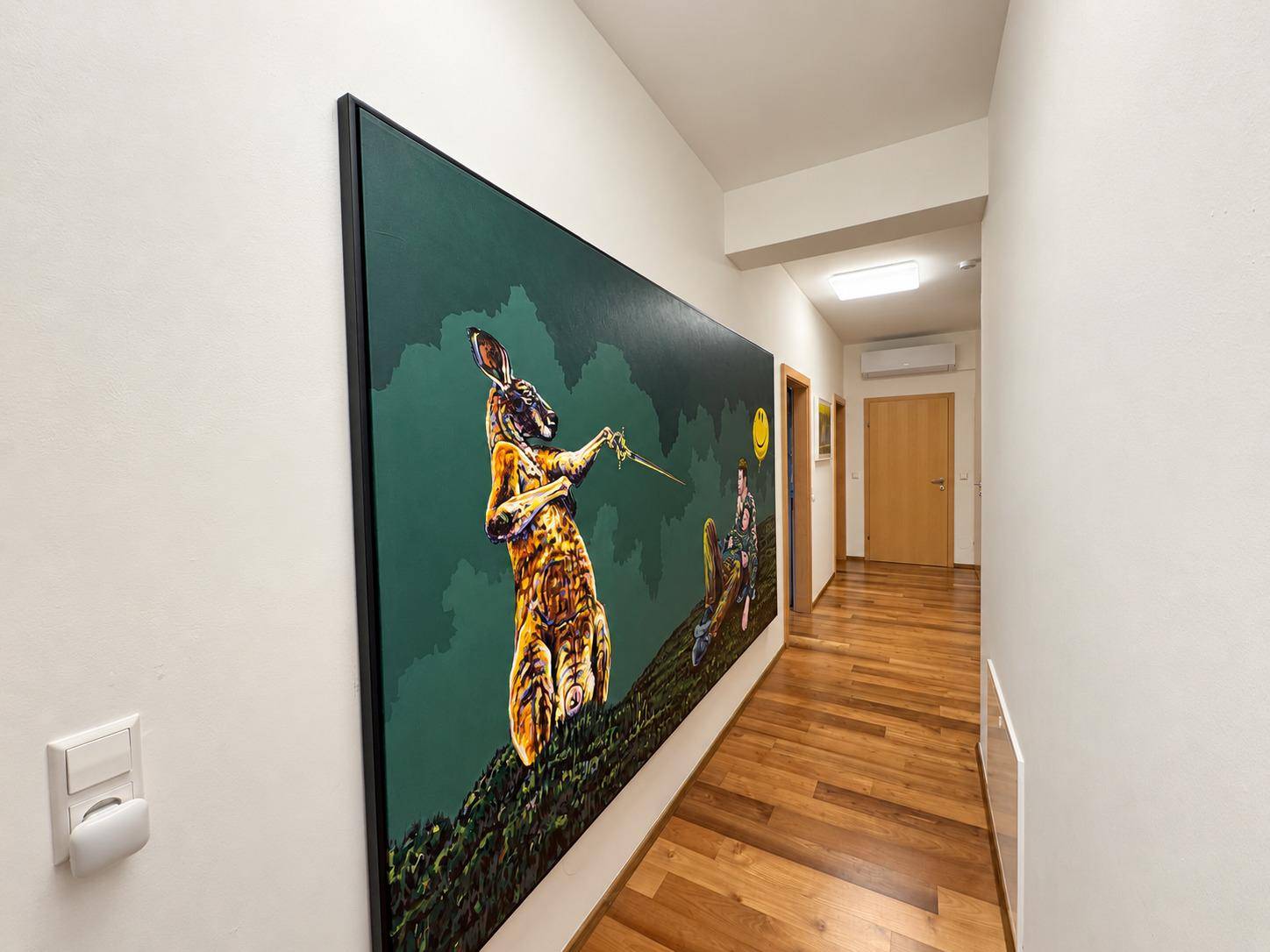 Heller Flur mit Holzboden und einem auffälligen, farbenfrohen Kunstwerk an der Wand.