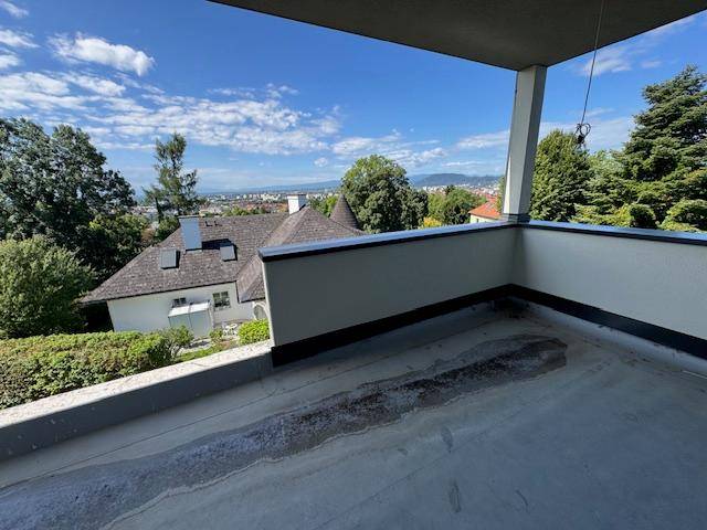 Unfertiger Balkon mit weitem Blick über die Stadt und die umliegende grüne Landschaft.