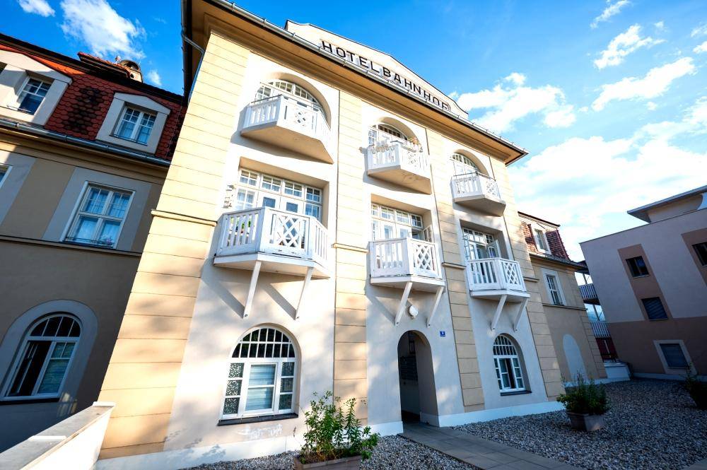 Fassade eines historischen Gebäudes mit dekorativen Balkonen und einem Eingangsbereich.