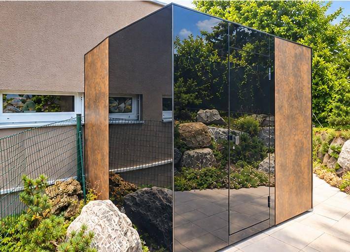 Moderner Gartenschuppen mit verspiegelter Fassade und Holzoptik-Seitenwänden im Steingarten.
