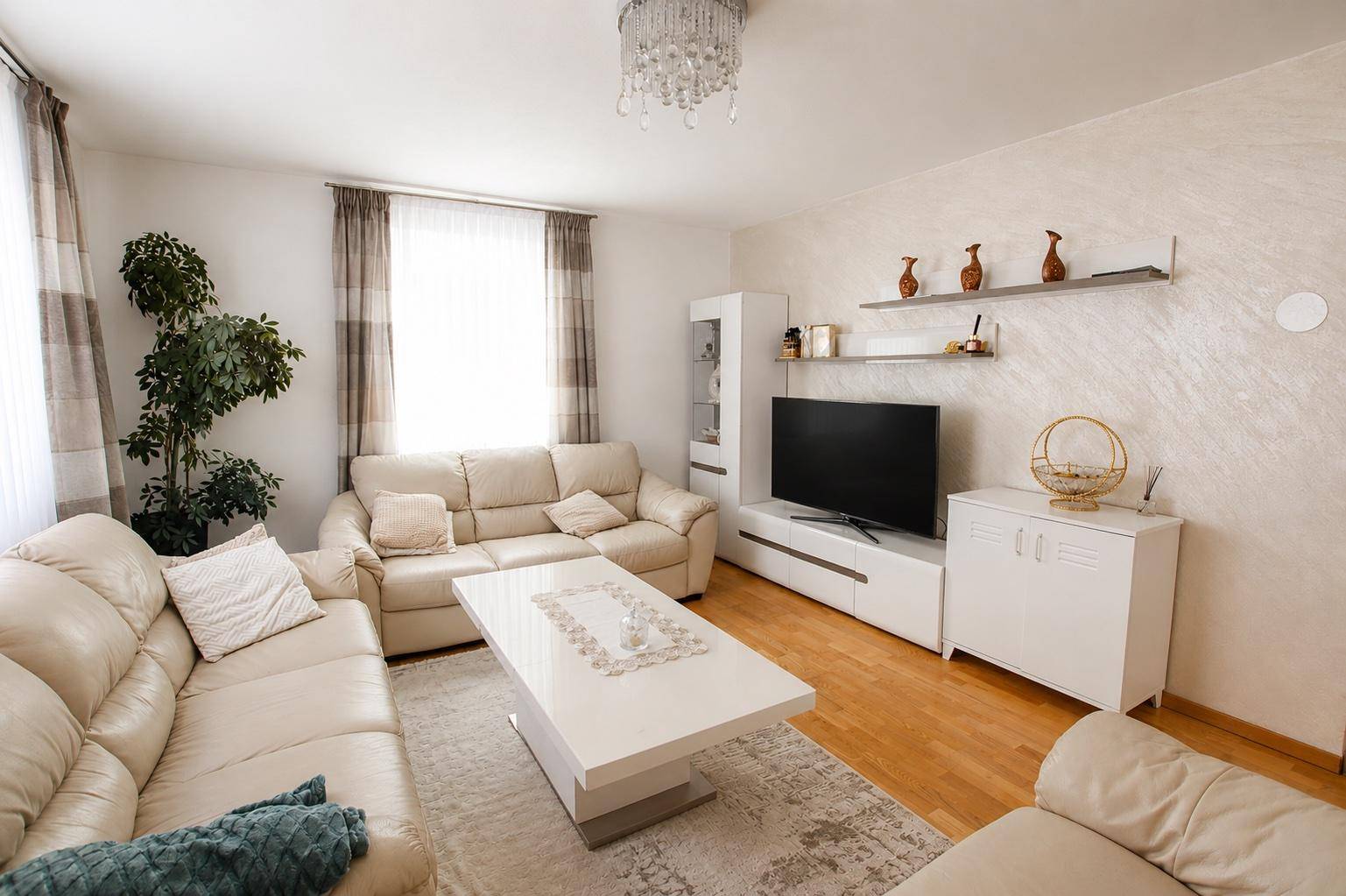 Gemütliches Wohnzimmer mit bequemen Sofas, Fernseher und dekorativen Elementen.