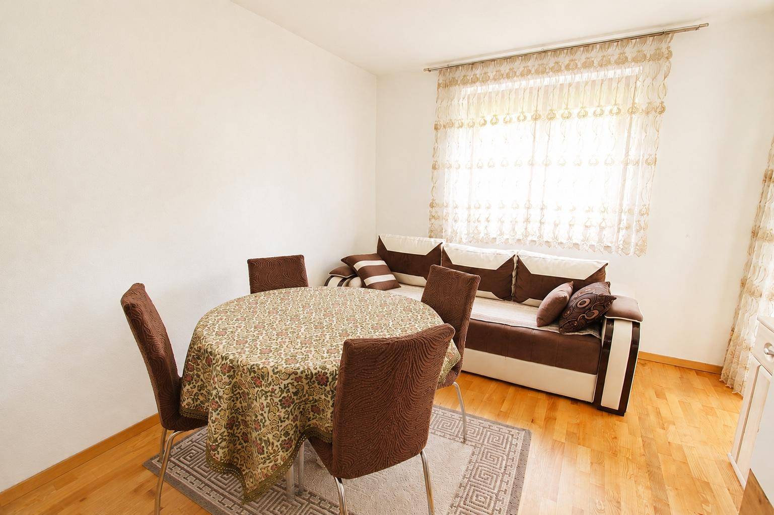 Kleinerer Raum mit Esstisch, Sofa und Fenster, ideal als Gäste- oder Arbeitszimmer.