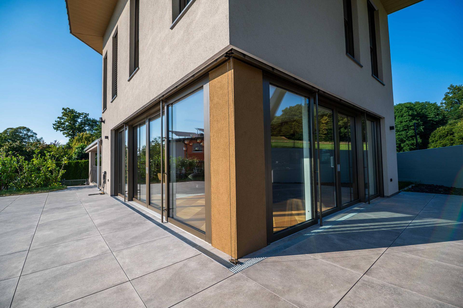 Moderne Architektur der Villa mit großen Glasfronten und Terrassenbereich.