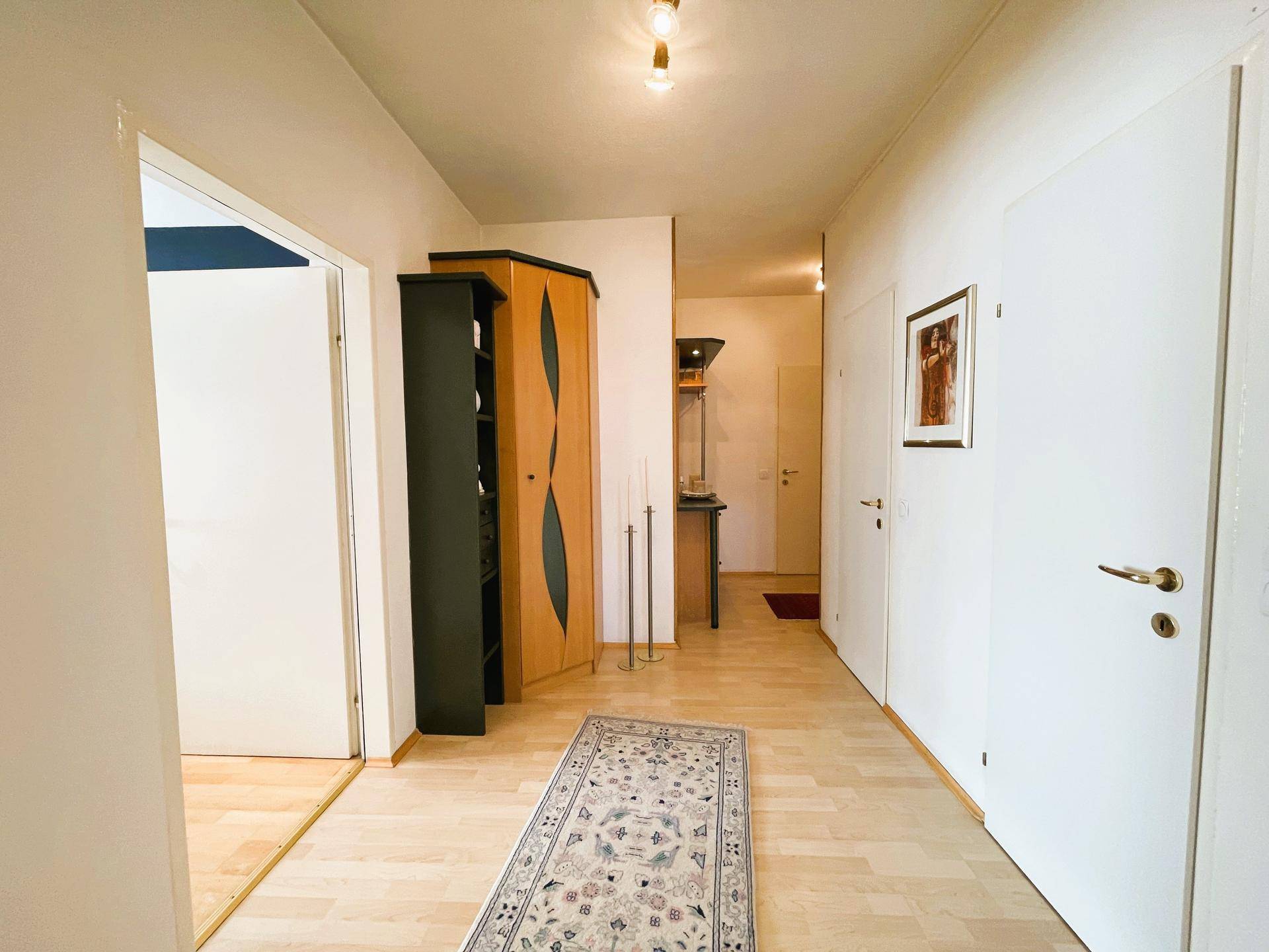 Geräumiger Flur mit Holzschrank und Zugang zu den angrenzenden Wohnbereichen.