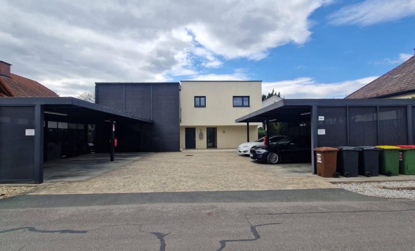 Gesamtansicht der modernen Wohnanlage mit mehreren Carports und Zufahrt.