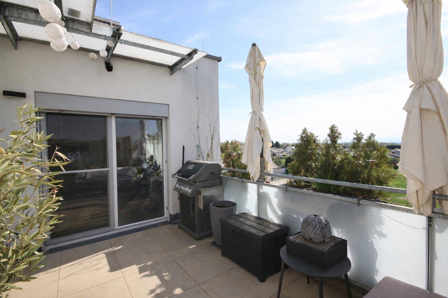 Terrasse mit Zugang zum Innenbereich, Grill und weitem Blick über die Landschaft.