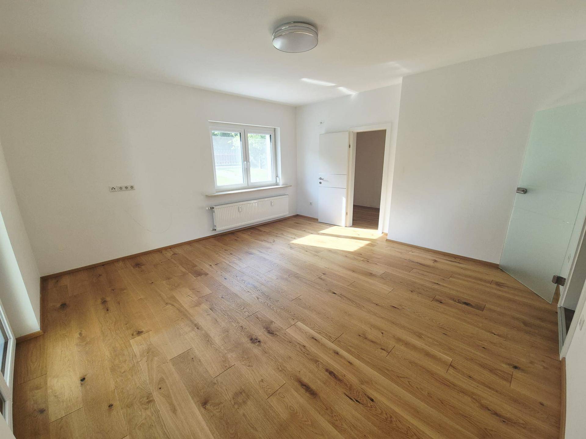 Geräumiges Schlafzimmer mit viel Tageslicht, Eichenparkett und Zugang zu angrenzenden Räumen.