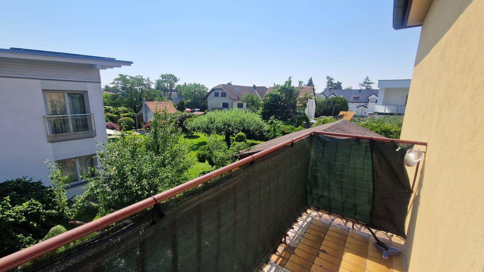 Balkon mit weitem Blick über die grüne Umgebung und die umliegenden Häuser der Nachbarschaft.