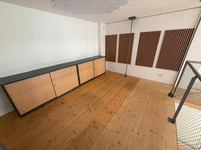 Galeriebereich mit einem langen Sideboard und dekorativen Holzlamellen an der Wand.