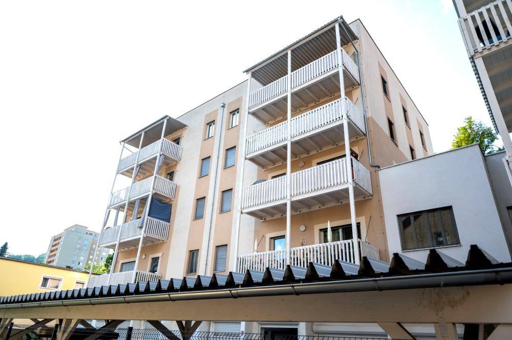 Fassade eines modernen Wohngebäudes mit gestuften Balkonen und klarem Himmel.