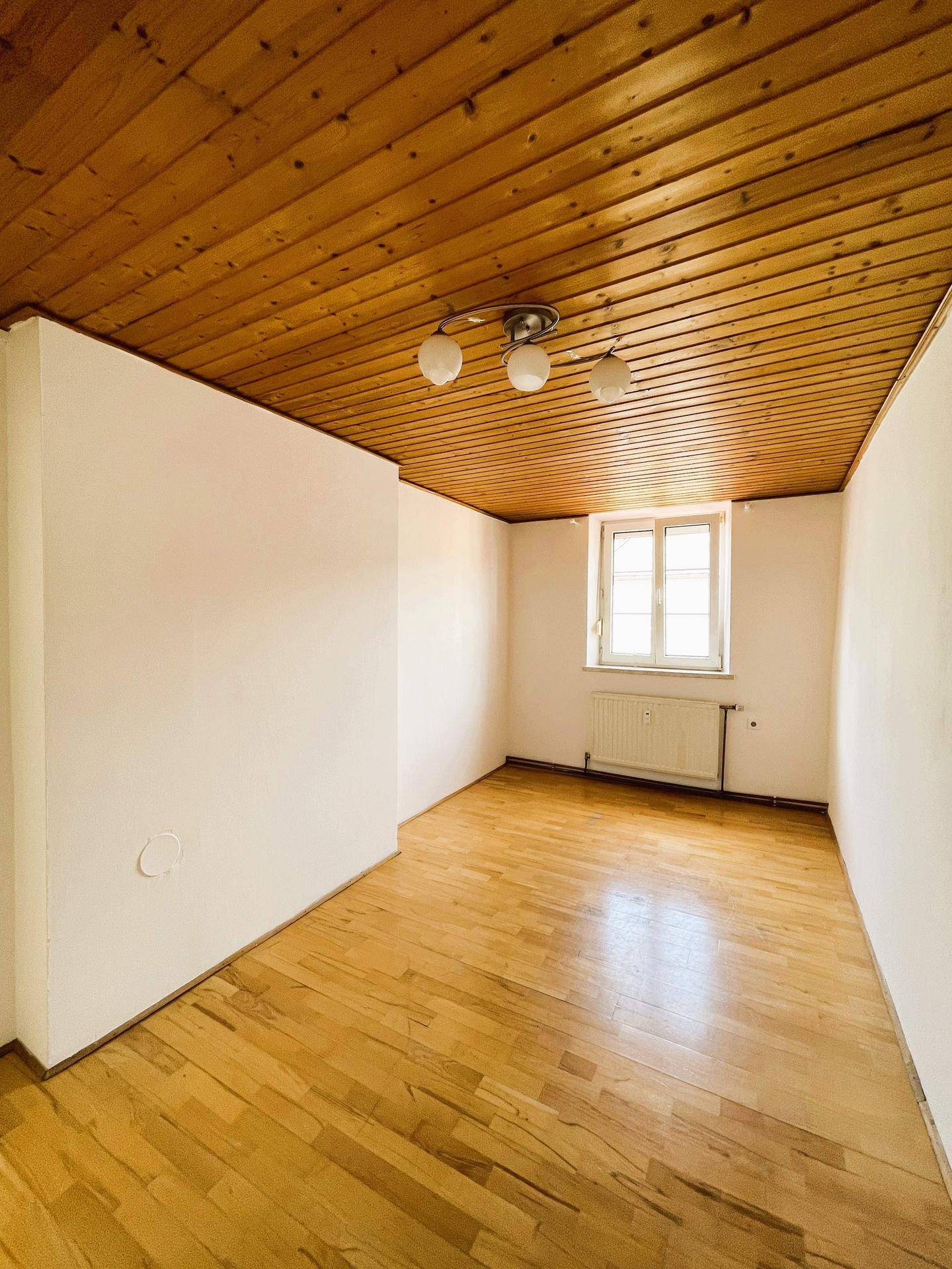 Heller Raum mit Holzdecke und Parkettboden, ideal für Schlaf- oder Wohnbereich.