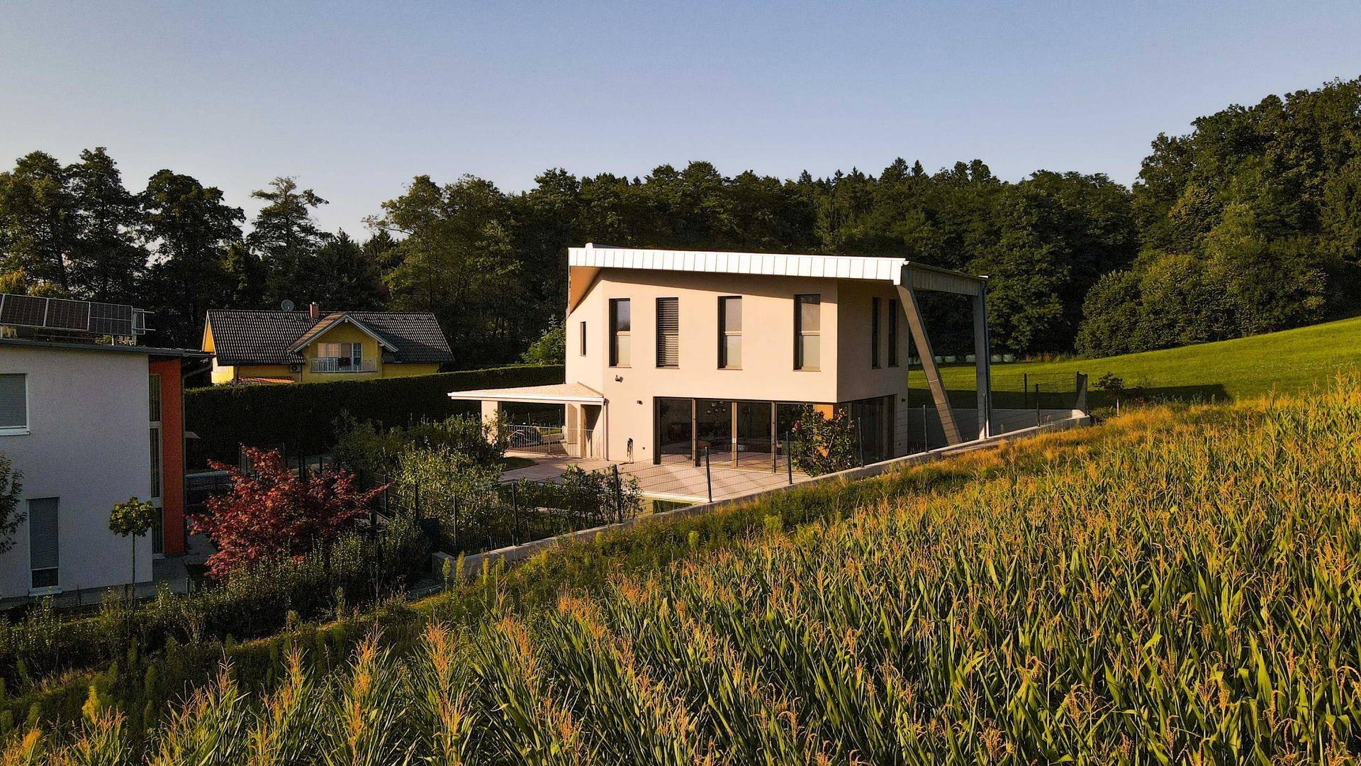 Weitläufige Ansicht der Villa in ländlicher Umgebung mit Feldern und Wald.