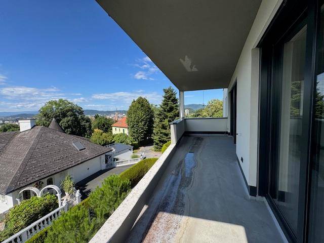 Langer, unfertiger Balkon mit Panoramablick über die Stadt und die bewaldete Umgebung.