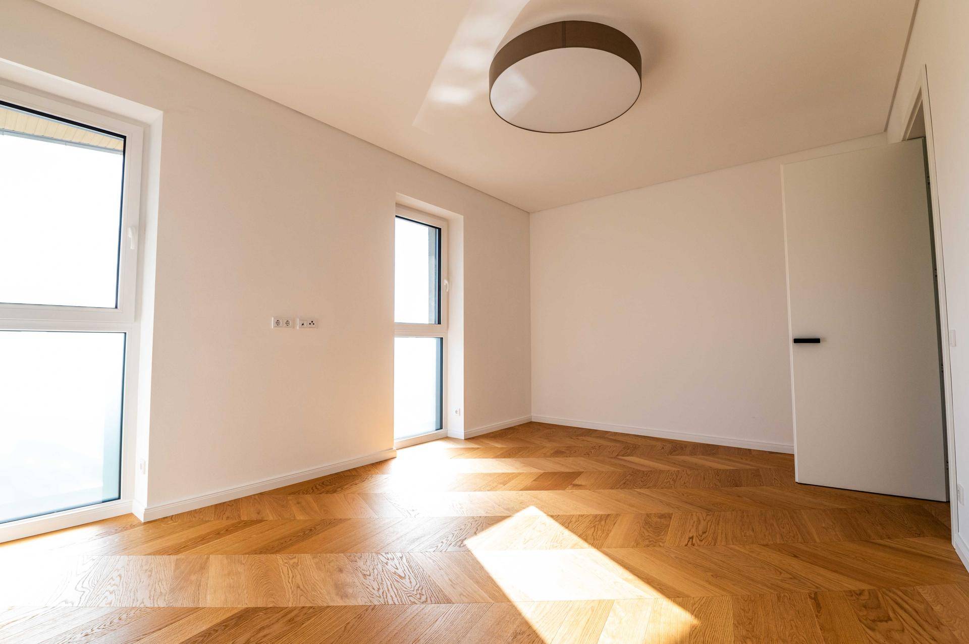 Geräumiges Schlafzimmer mit Holzboden und viel natürlichem Licht.