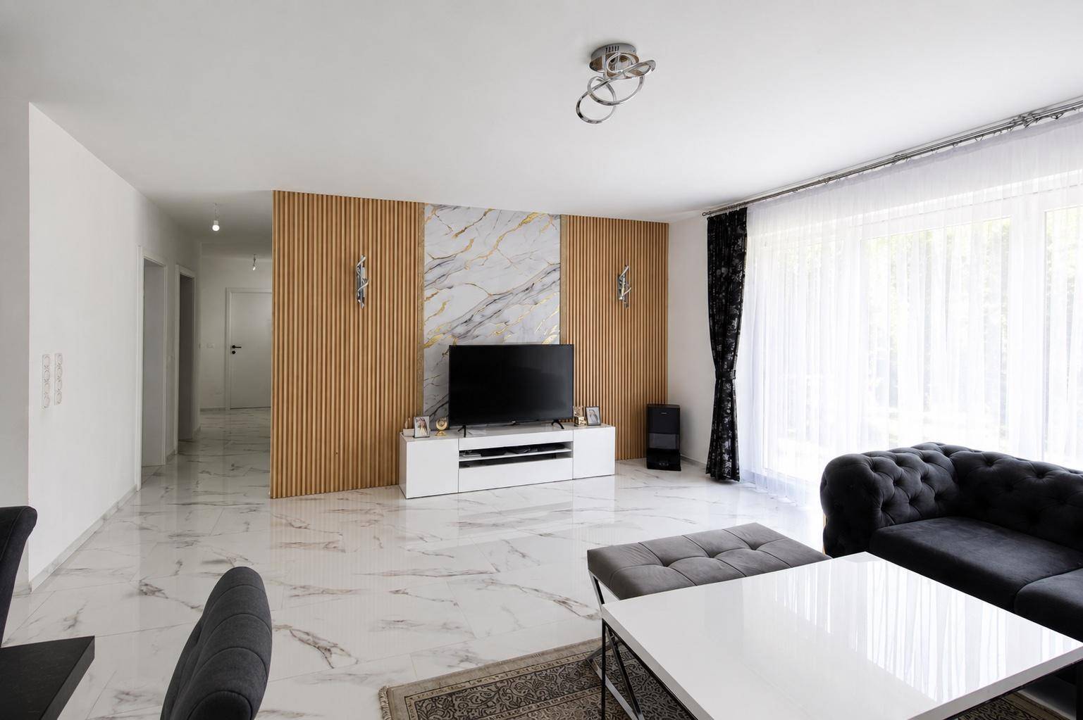 Moderner Wohnbereich mit stilvoller Wandgestaltung, großem Sofa und Fernseher.
