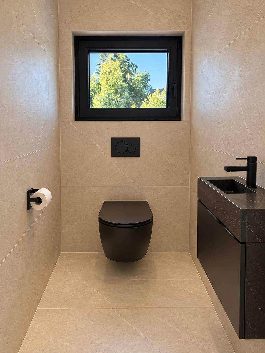 Modernes Gäste-WC mit dunkler Toilette, passendem Waschbecken und Fenster für Tageslicht.