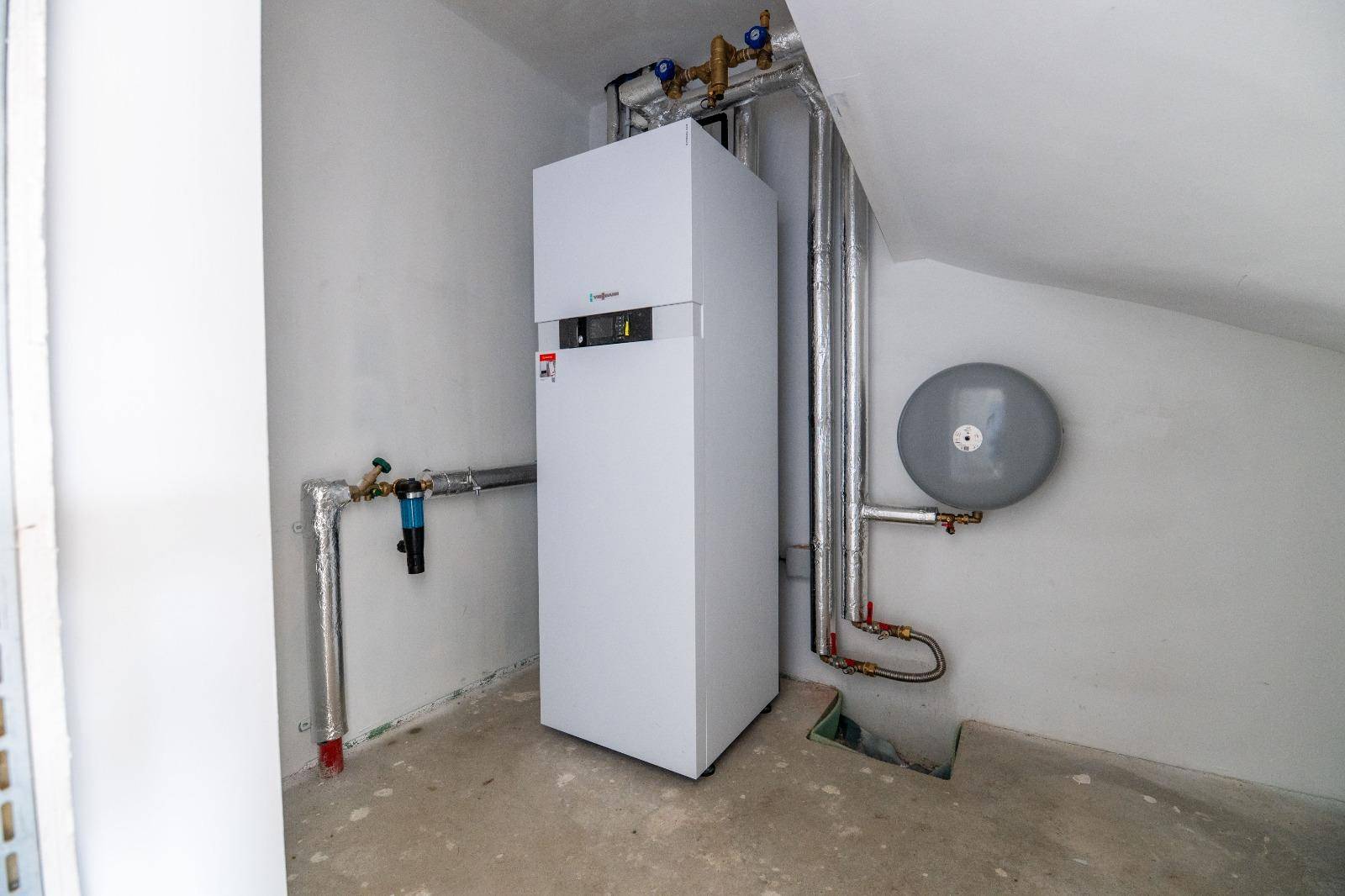 Hauswirtschaftsraum mit moderner Viessmann Heizungsanlage und sichtbaren Rohren.