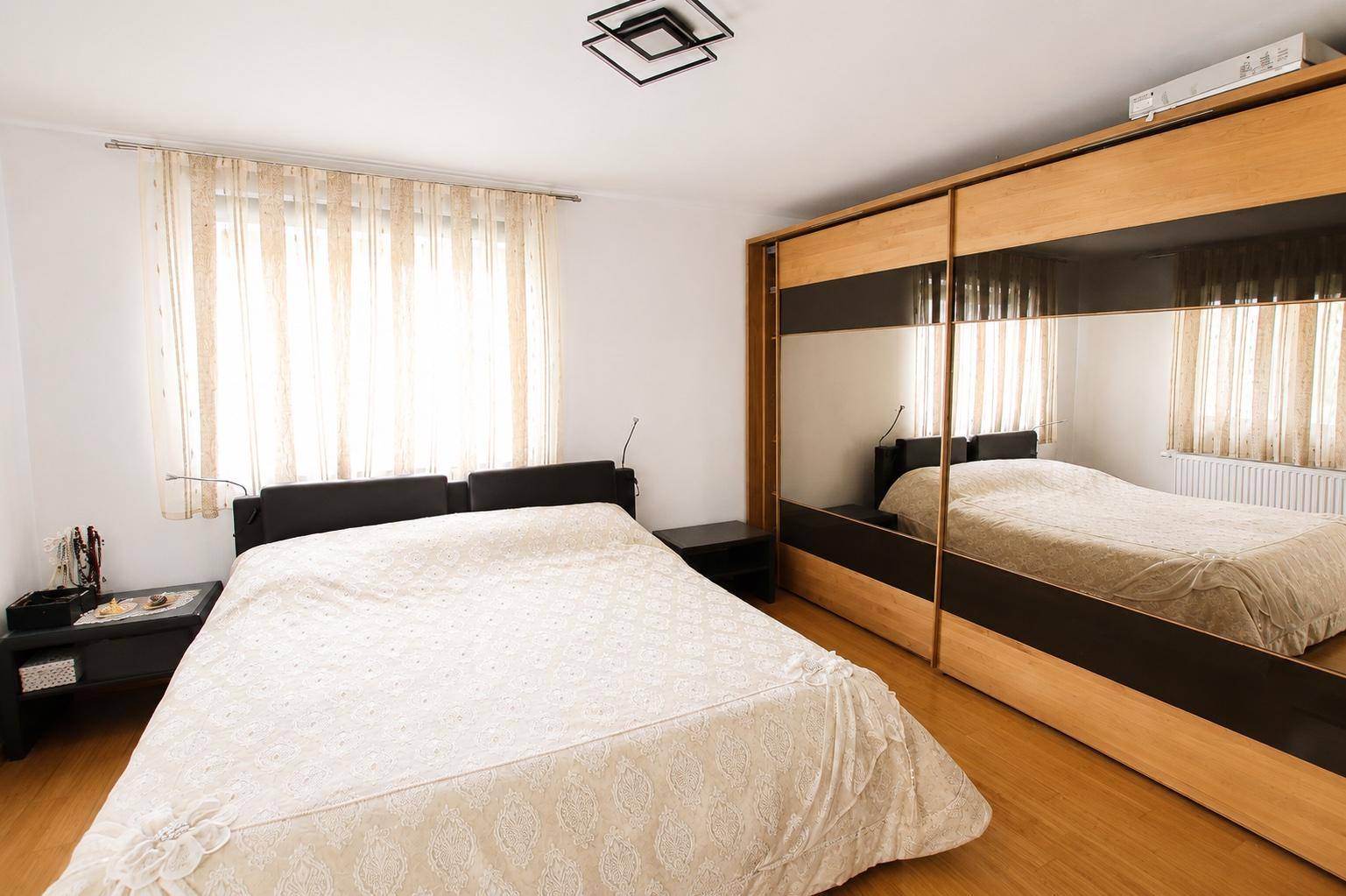 Hauptschlafzimmer mit Doppelbett und großem Spiegelschrank, der den Raum optisch vergrößert.