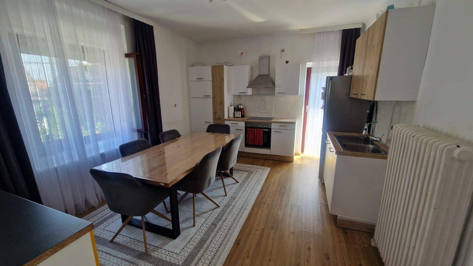 Helle Wohnküche mit Essbereich, Holzboden und modernen Küchenschränken, ideal für Familien.