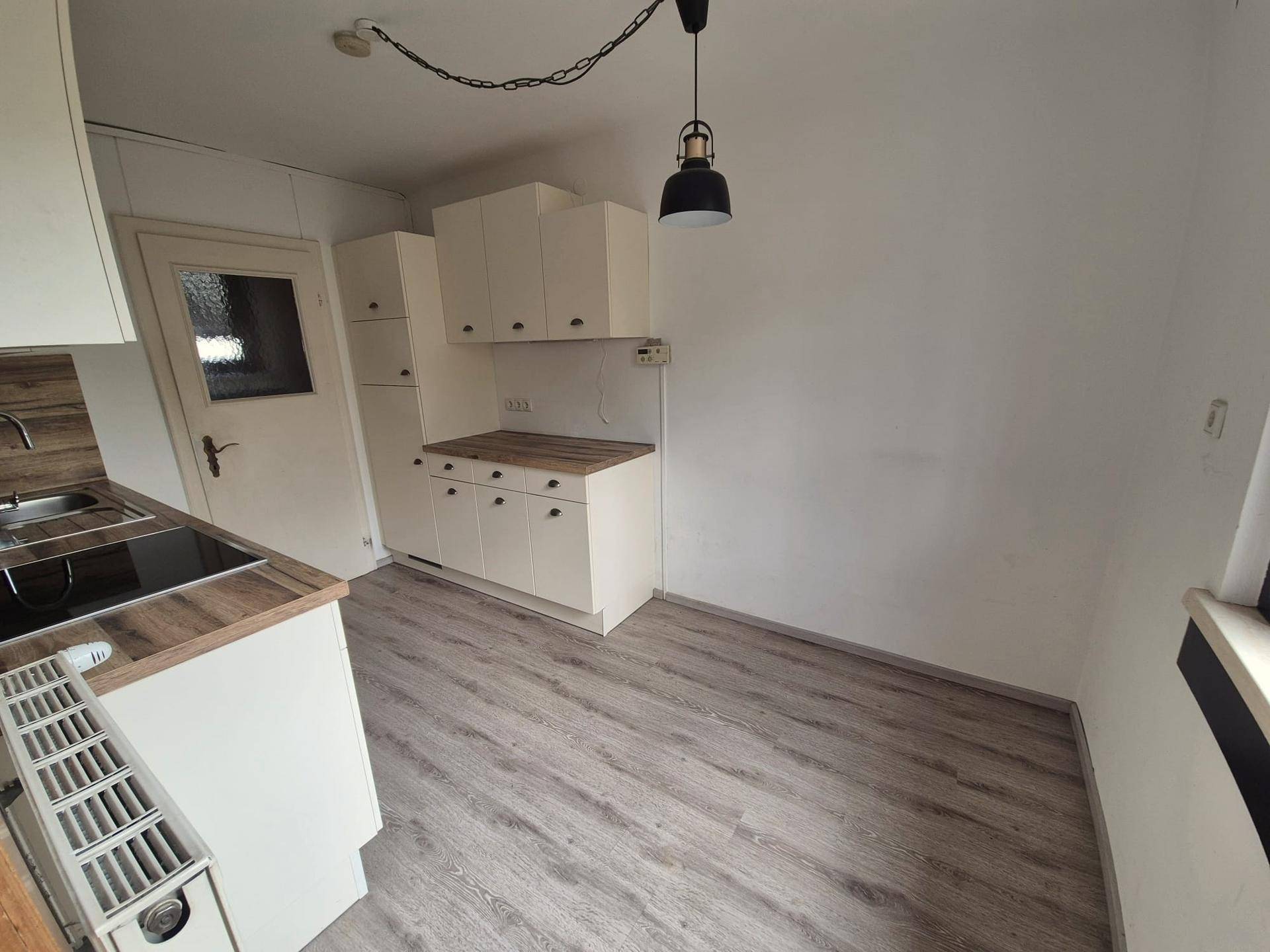 Funktionale Küche mit weißen Unterschränken und Holz-Arbeitsplatten, bereit zur Nutzung.