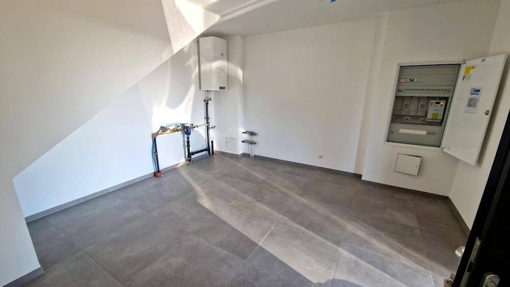 Technikraum mit Fliesenboden, Warmwasserbereiter und elektrischem Verteilerkasten.