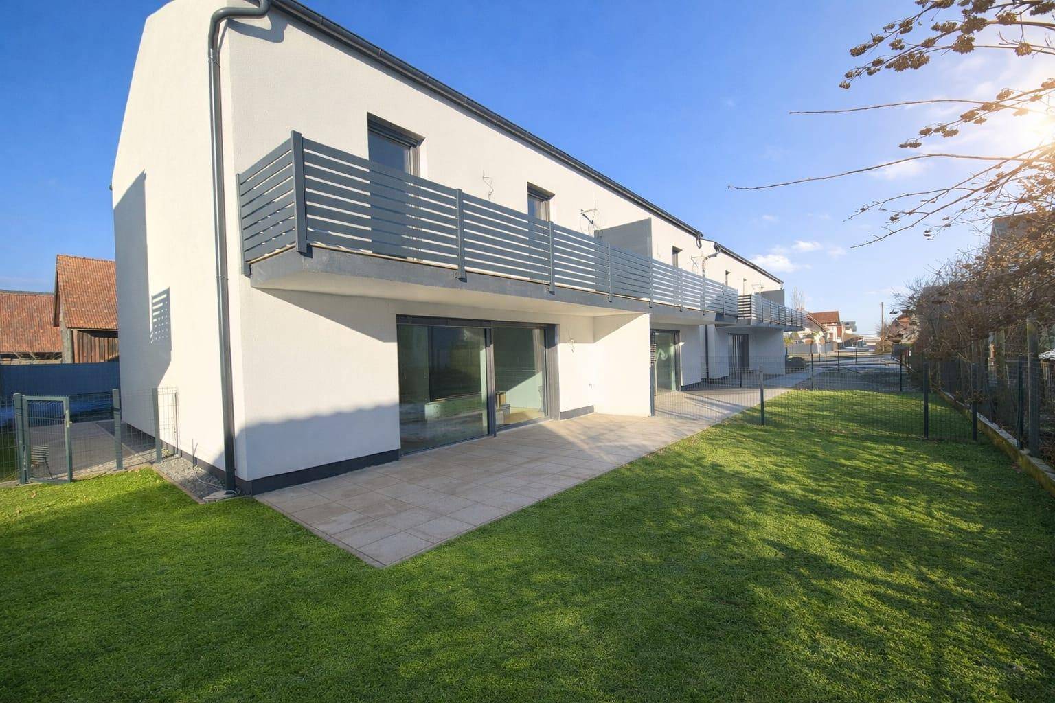 Moderne Reihenhäuser mit Terrassen und Gärten, ideal für Familien, in sonniger Lage.