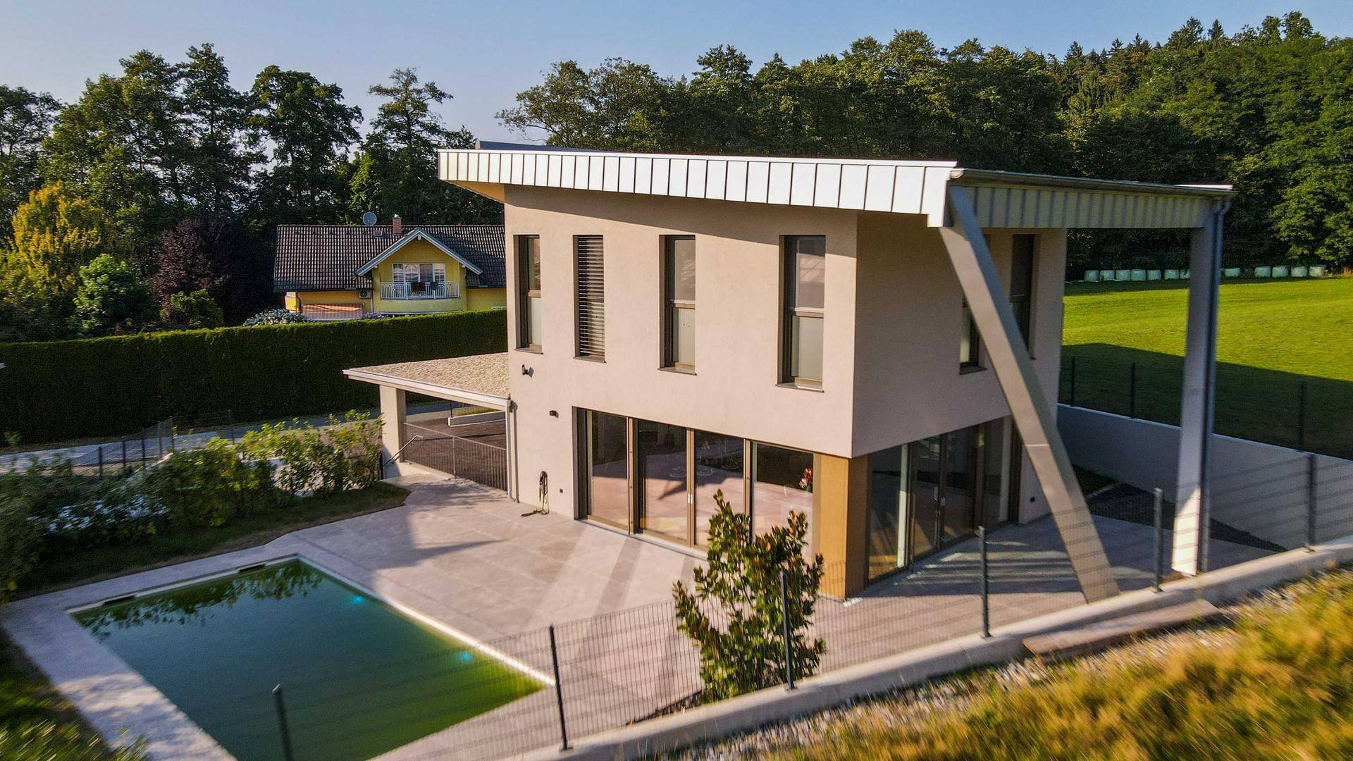 Luftaufnahme der modernen Villa mit Pool und angrenzenden Feldern.