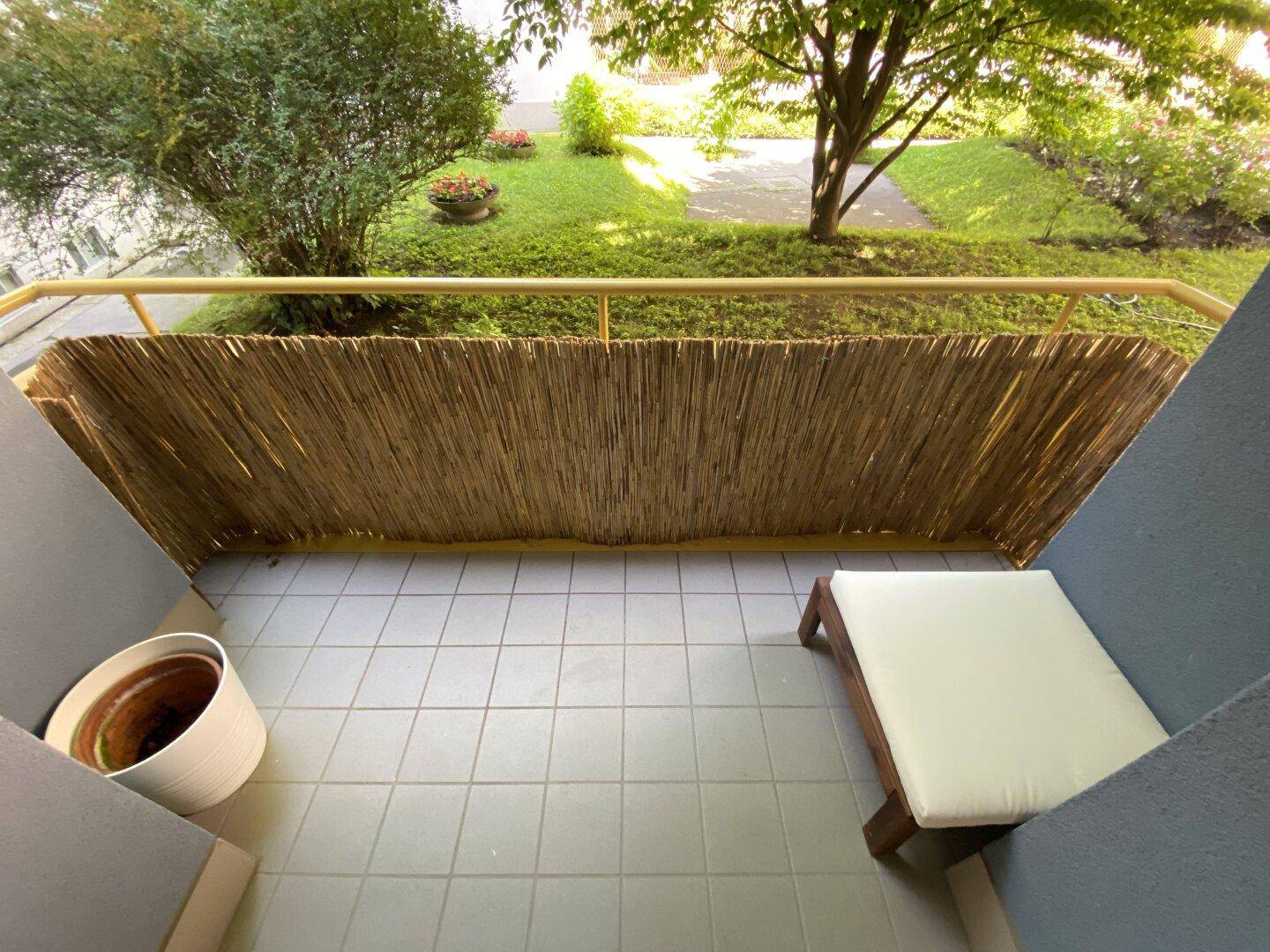 Kleiner Balkon mit Fliesenboden und Sichtschutz, ideal für entspannte Stunden.