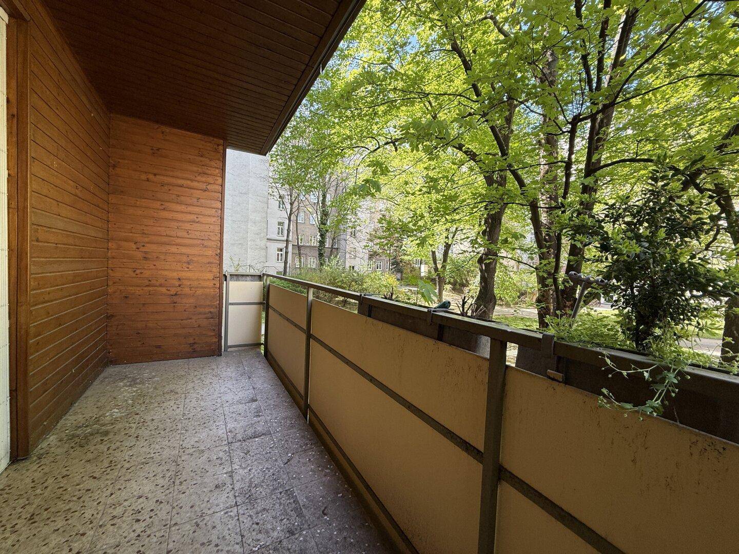 Balkon mit Holzverkleidung und Blick ins Grüne, ideal für entspannte Stunden im Freien.