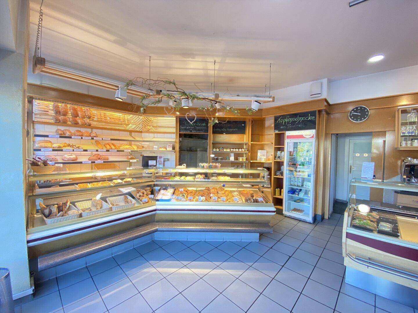 Detailansicht des Bäckerei-Verkaufsraums mit reichhaltiger Auslage und Kühlvitrine.