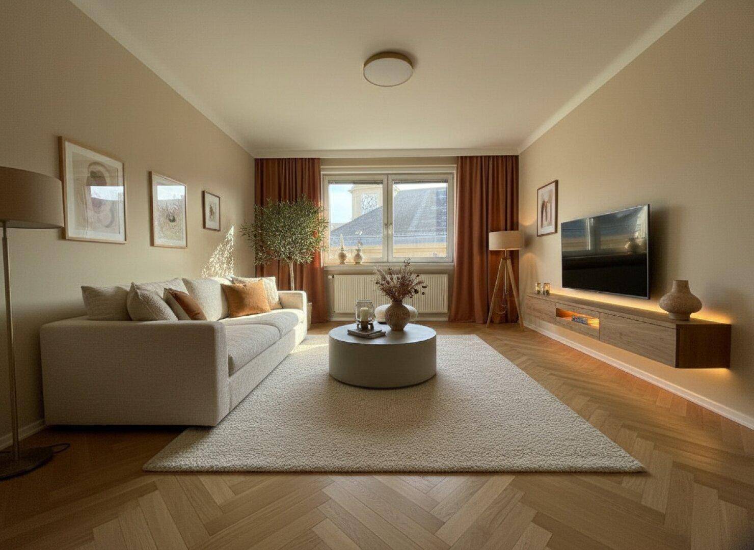 Helles Wohnzimmer mit elegantem Fischgrätparkett, beigefarbenen Wänden und moderner Einrichtung.
