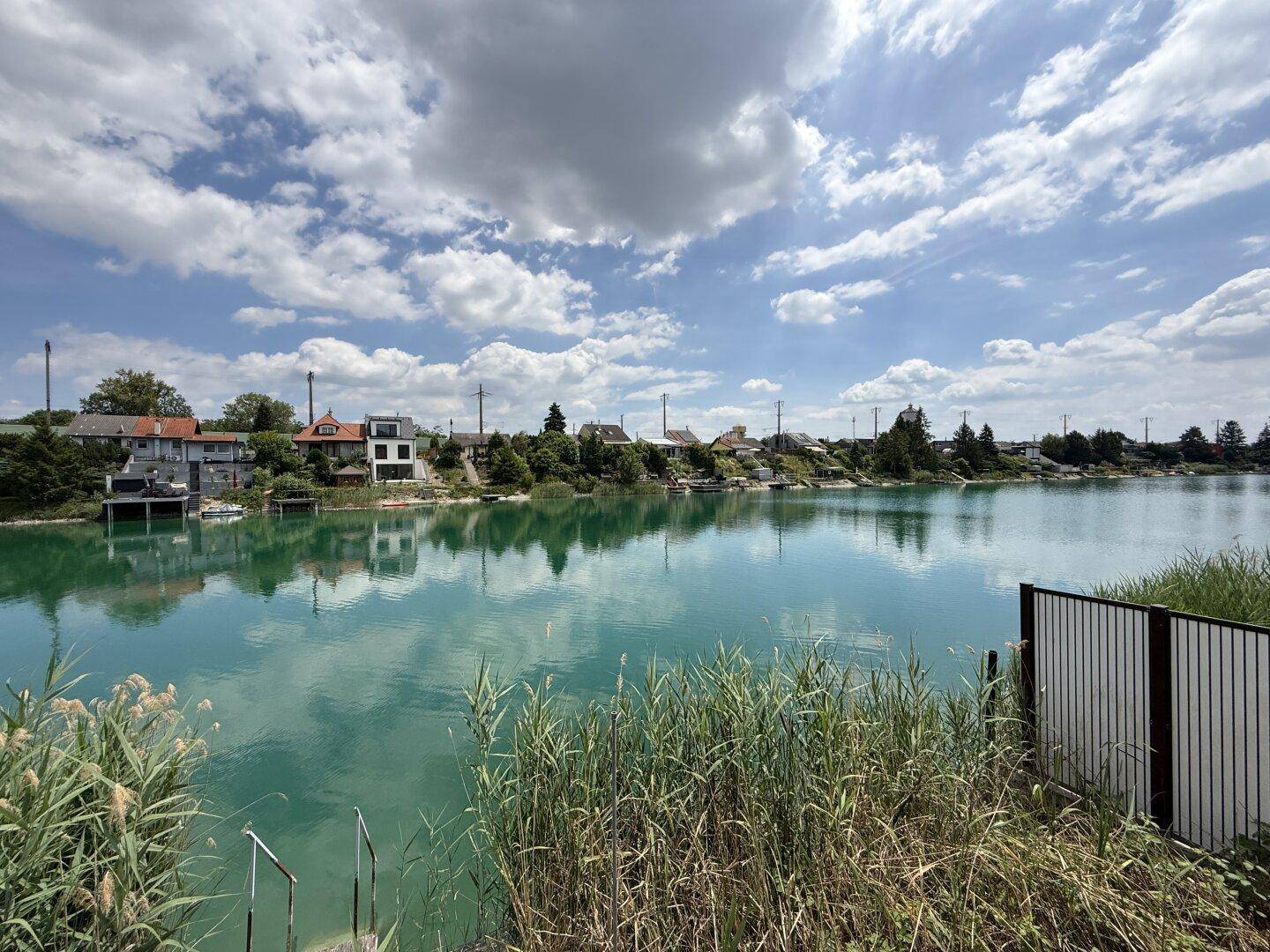 Malerischer Blick auf den See mit Häusern am Ufer, umgeben von Schilf.