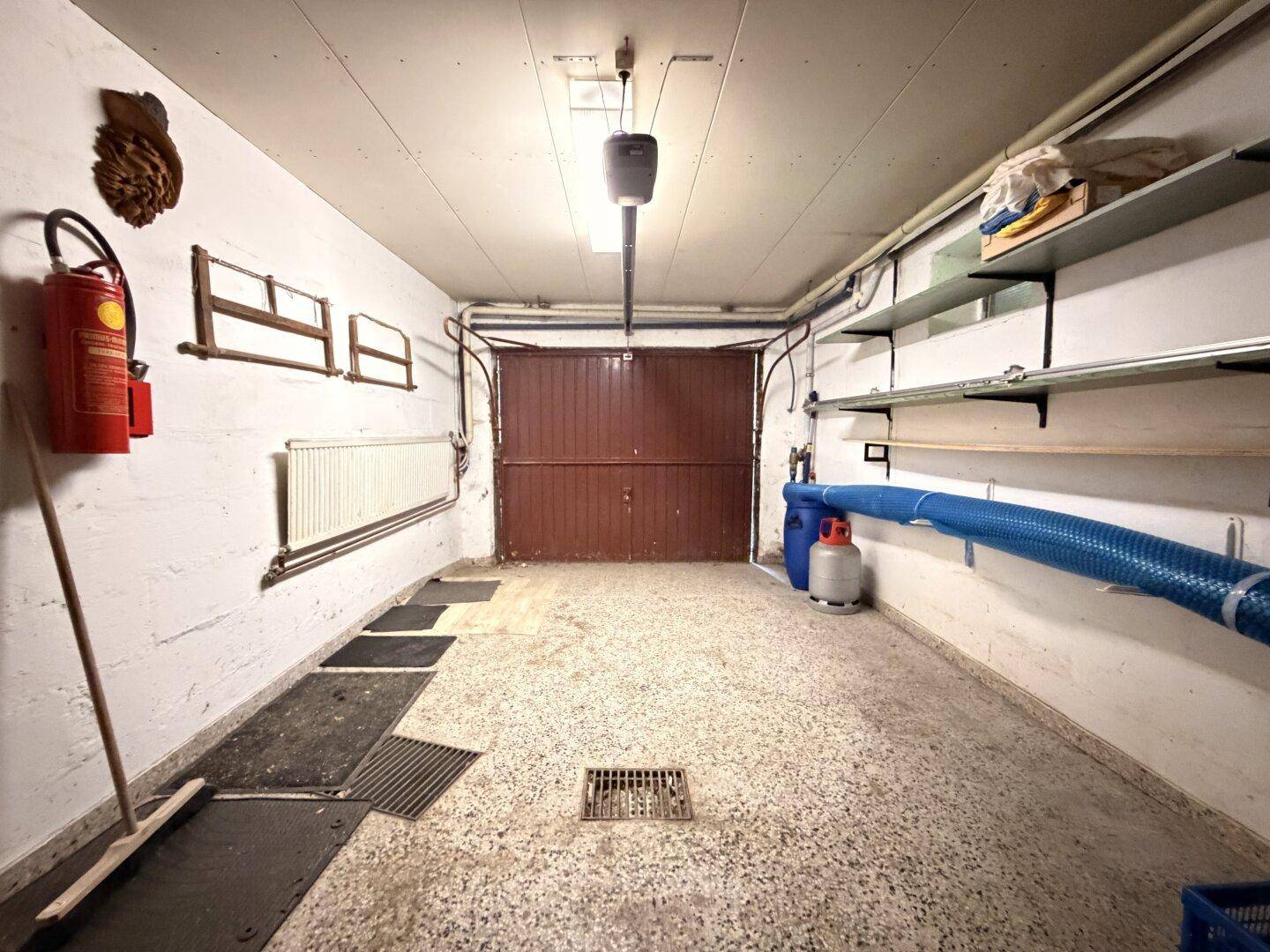 Geräumige Garage im Keller mit Rolltor und ausreichend Platz für ein Fahrzeug.