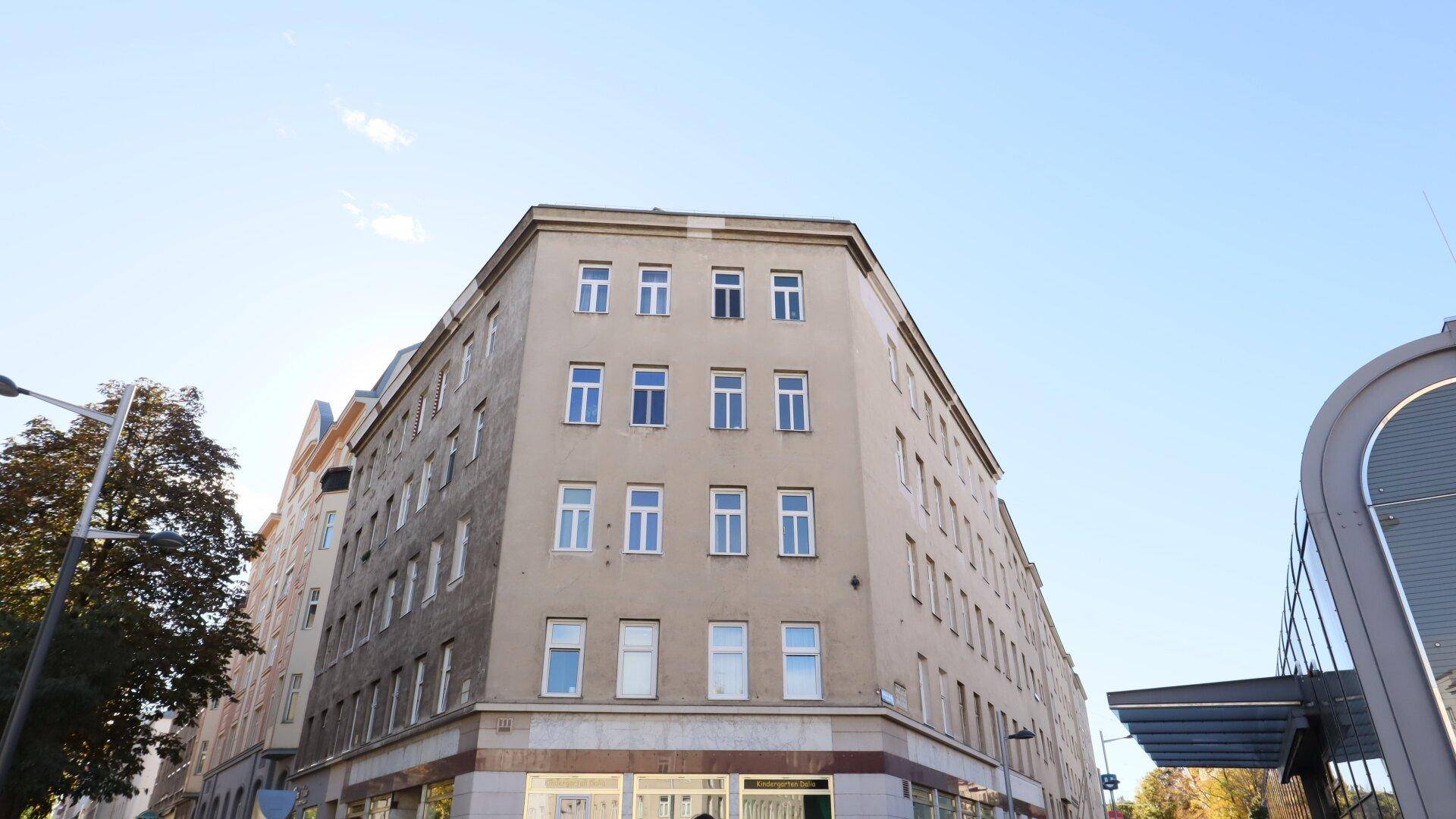 Historisches Mehrfamilienhaus mit klassischer Fassade und vielen Fenstern an einer Straßenecke.
