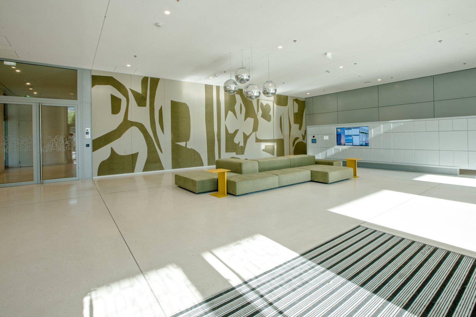 Geräumige und helle Lobby mit moderner Kunst und bequemen Sitzgelegenheiten.