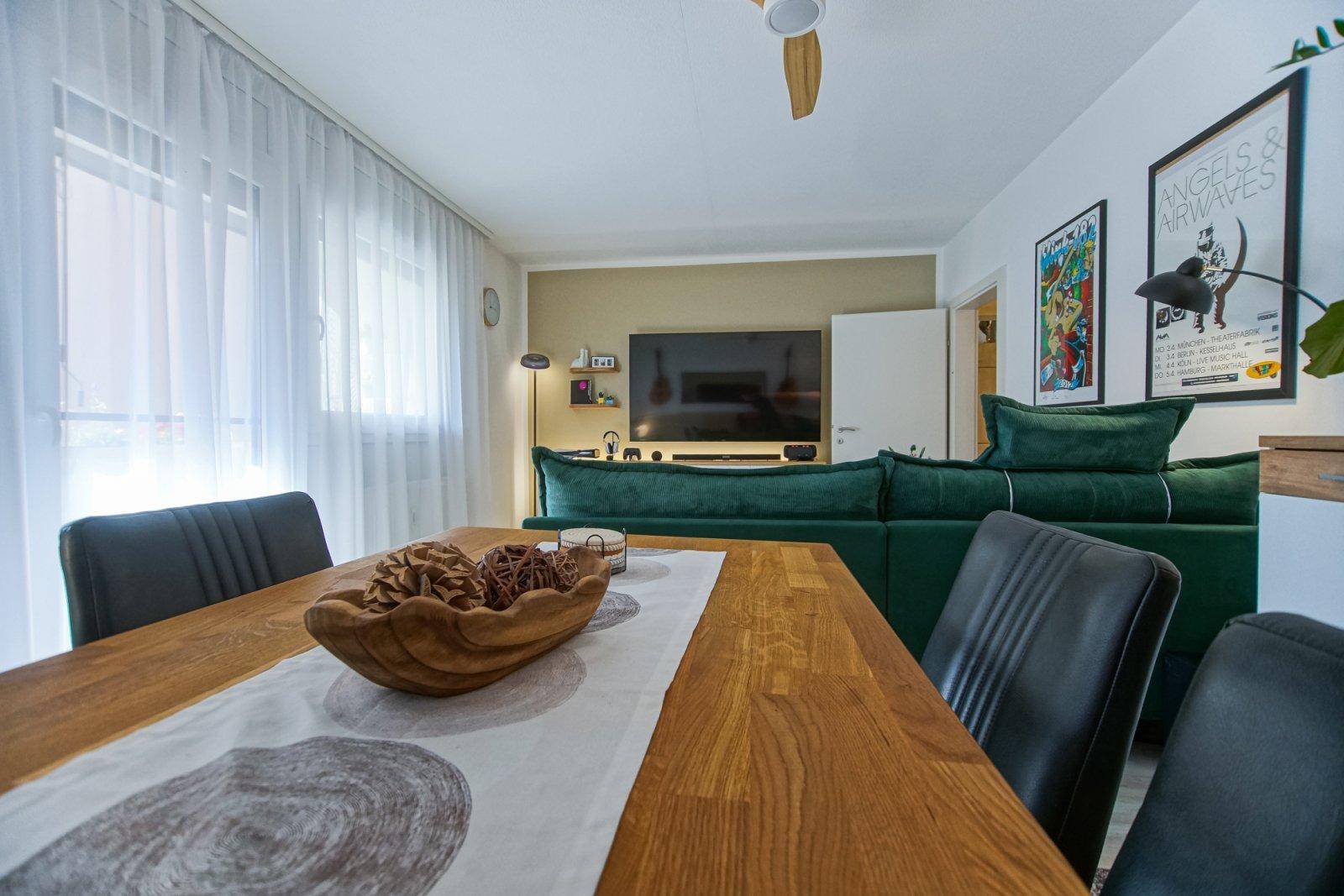Essbereich mit Holztisch und schwarzen Stühlen, integriert in den offenen Wohnbereich.