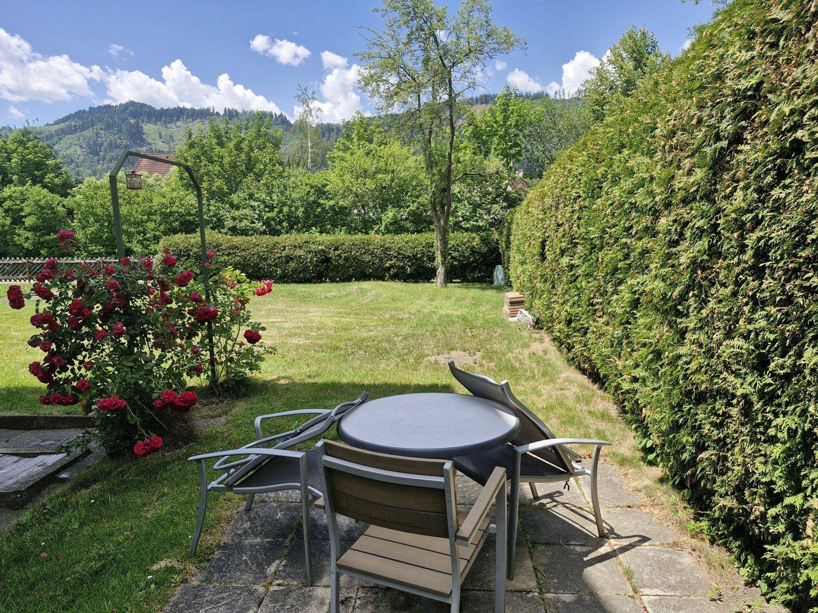 Gemütliche Terrasse mit Gartenmöbeln und weitem Blick auf die umliegende Berglandschaft.