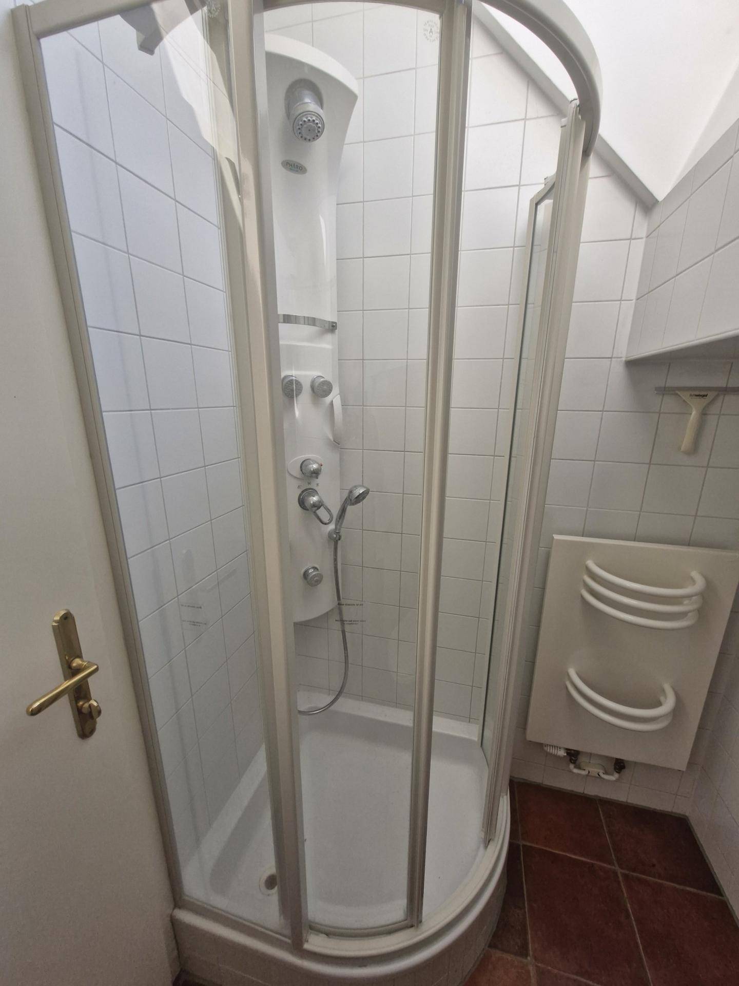 Duschkabine mit Massagedüsen in einem gefliesten Badezimmer, ideal für Entspannung.